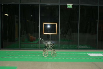 Q202-AtelierRundgang 2013, Rivergate.  Kinderwagen mit leerem goldenen Bilderrahmen fährt zwischen funkelden Kristallen Richtung Notenblatt eines alten Wienerliedes.  Hans Heisz