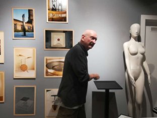 Hans Heisz bei der Ausstellung Droge Gold vor einigen Bildern seiner früheren Arbeiten.